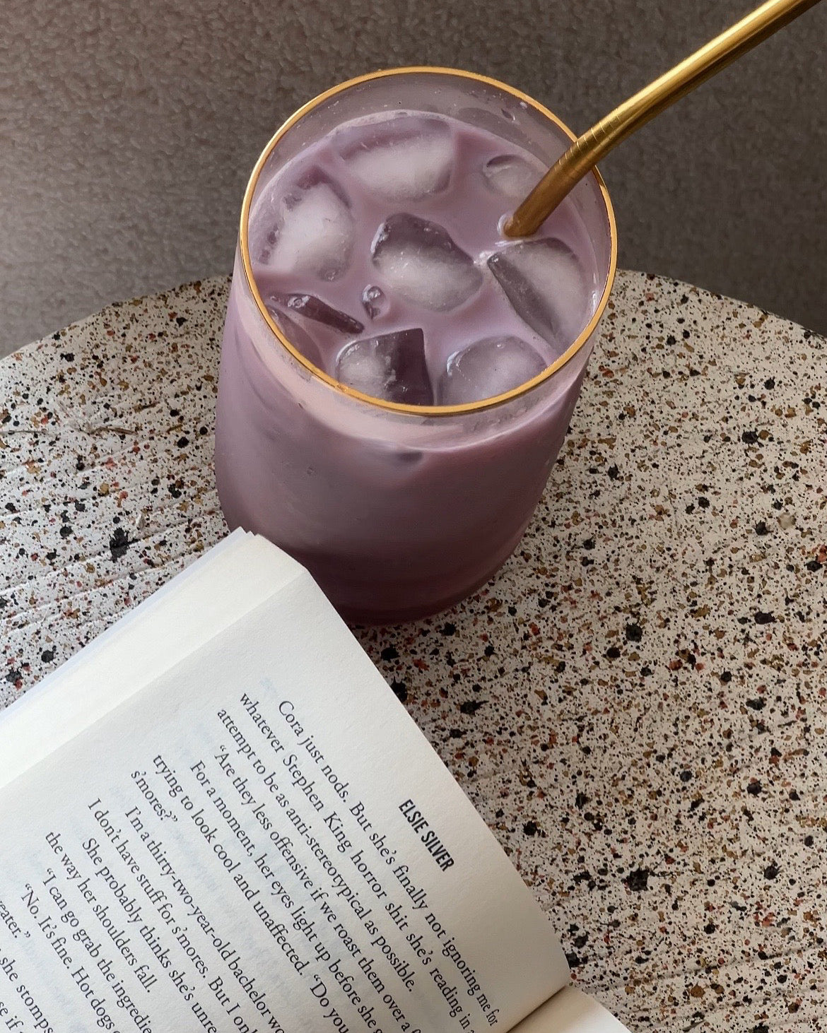 glass of purple matcha with a book 